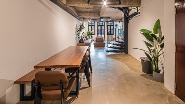 Modern event space at TERRA LOFT, featuring a long wooden table and natural light.