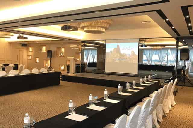Professional meeting space at Royal Palm, featuring organized seating and presentation screen.