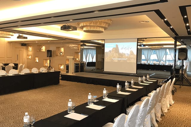Professional meeting space at Royal Palm, featuring organized seating and presentation screen.