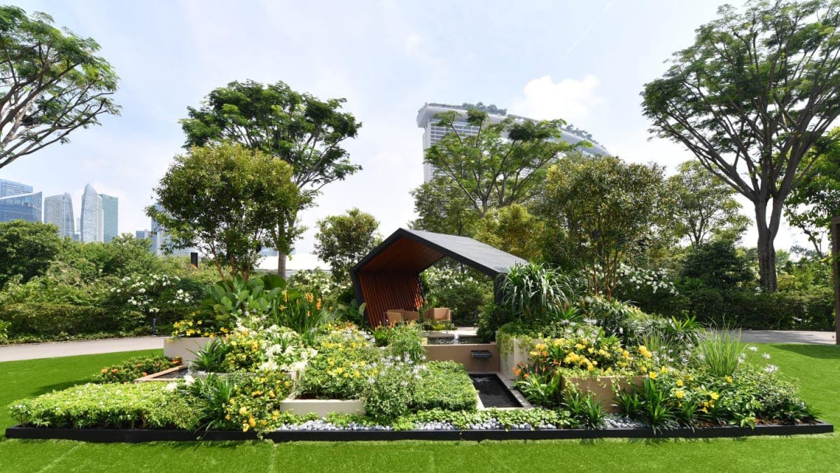 Lush outdoor event space in Singapore with vibrant flowers and modern structure.