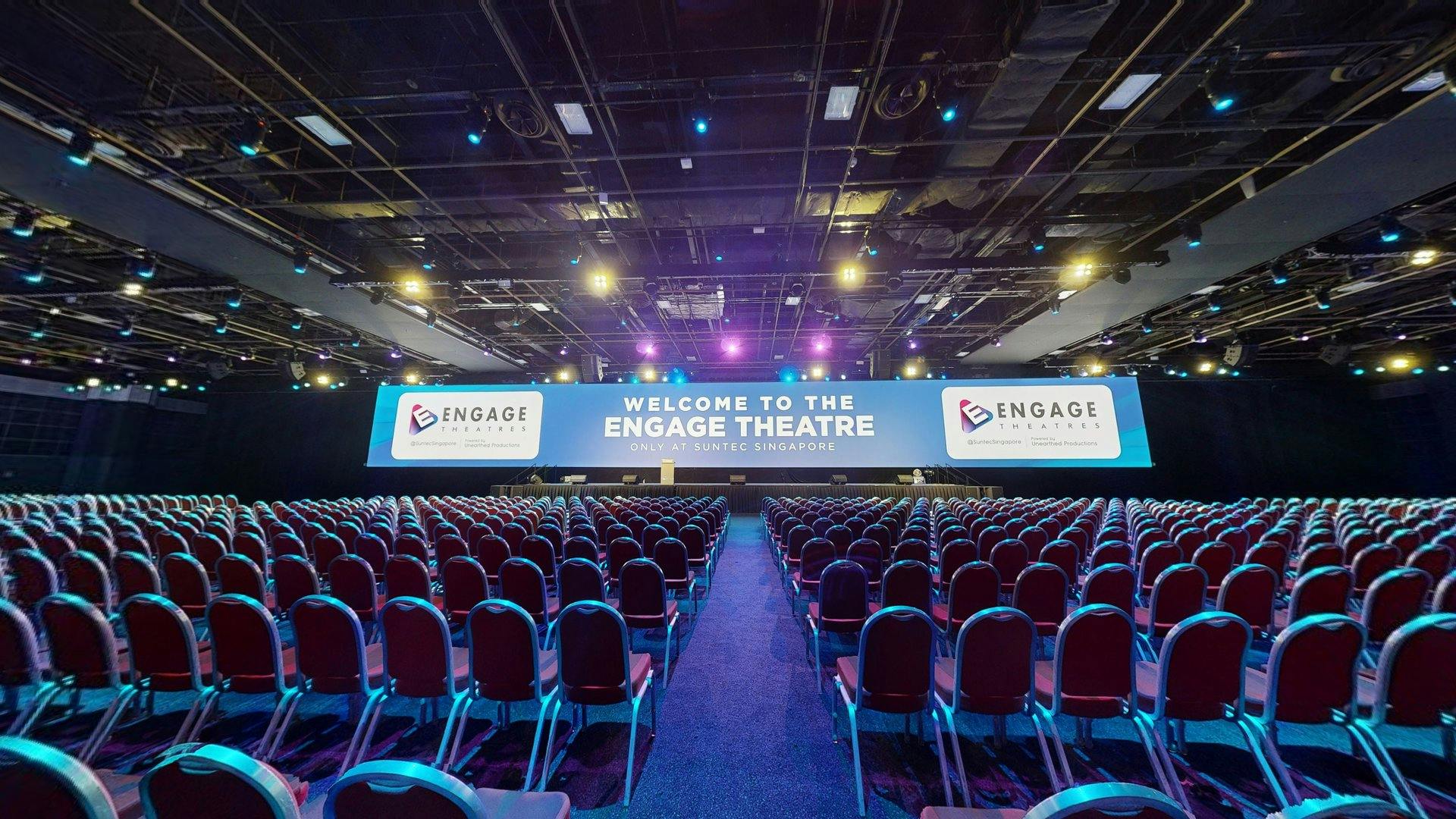 Engage Theatres setup with red chairs for a professional conference in Singapore.