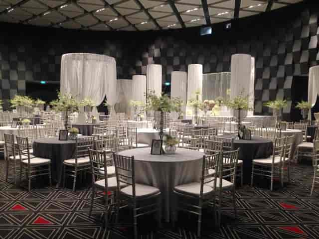 Elegant event space with round tables and floral centerpieces for weddings and corporate events.