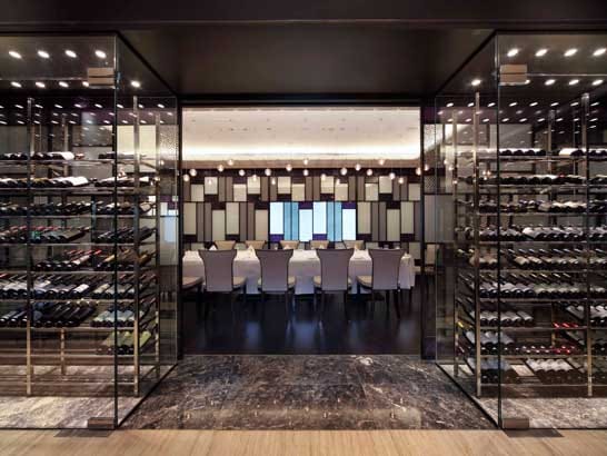 Sophisticated meeting space with elegant chairs and wine display at The American Club Singapore.