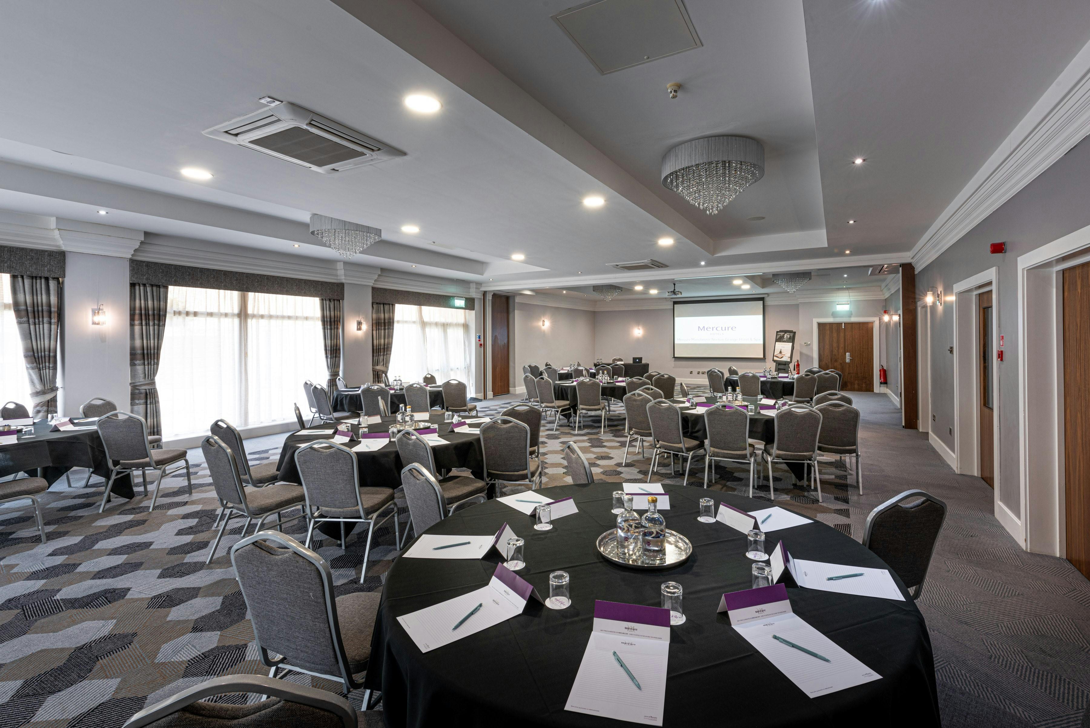 Function room in Rochdale with round tables, ideal for corporate events and workshops.