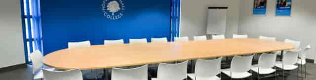 Modern conference room in Rochdale with wooden table, ideal for meetings and workshops.