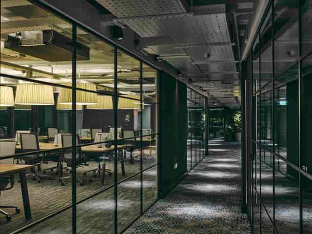 Modern co-working space corridor with glass meeting rooms, ideal for collaboration events.