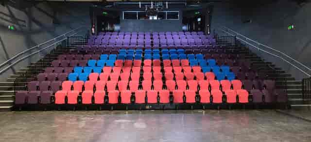Vibrant music studio with tiered seating in purple, blue, and red for engaging performances.