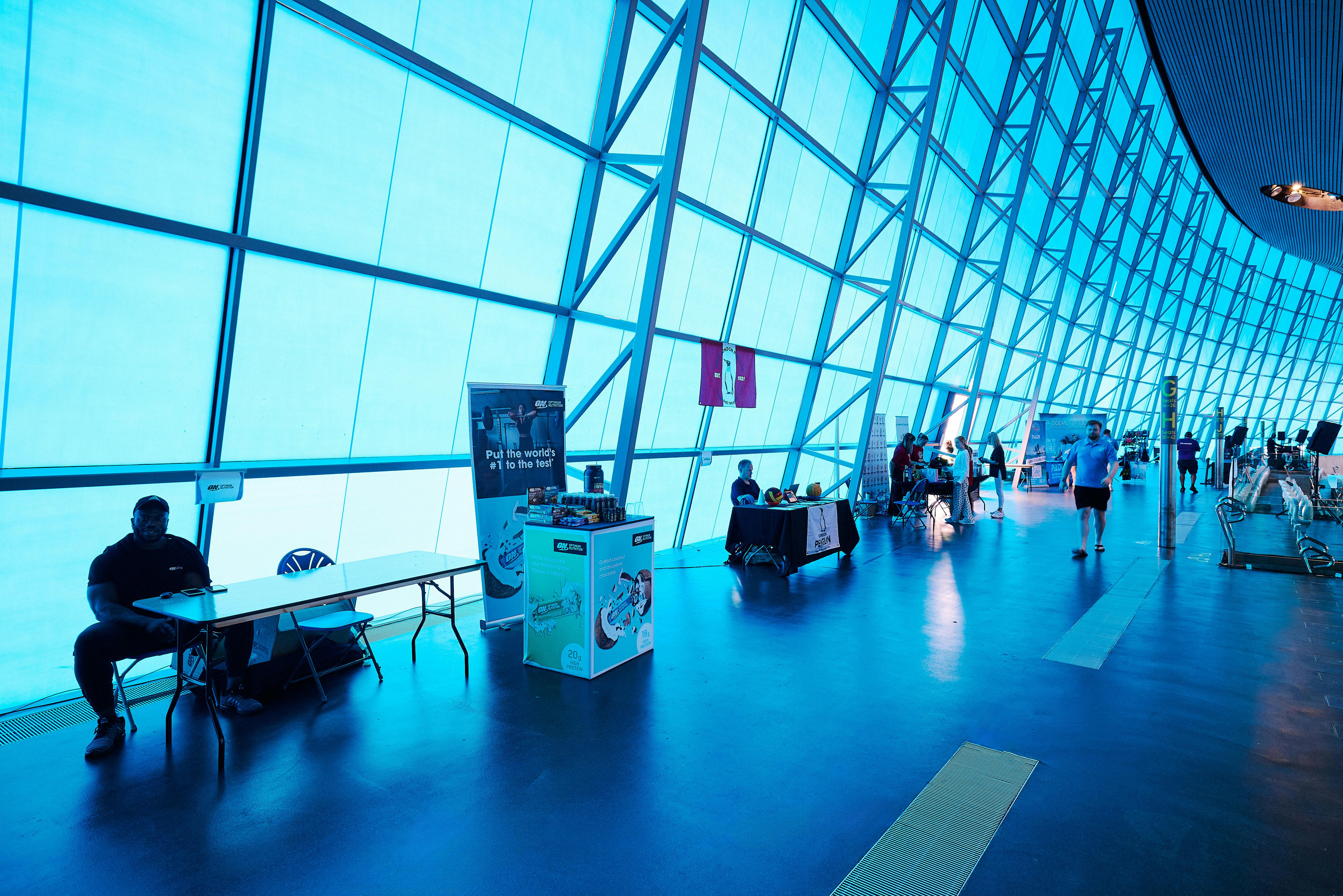 Modern event space in London Aquatics Centre with blue lighting for conferences.
