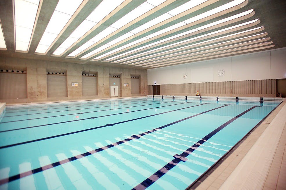 Modern indoor swimming pool at London Aquatics Centre for wellness retreats and team-building.