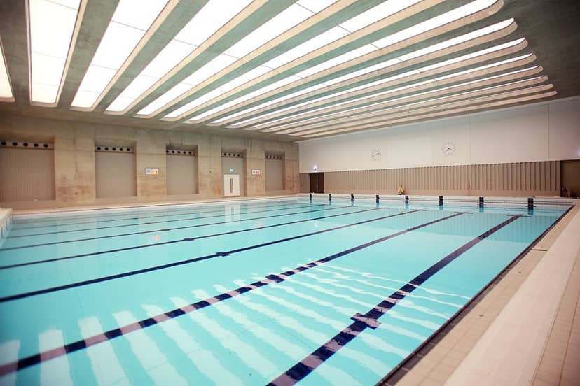 Modern indoor swimming pool at London Aquatics Centre for wellness retreats and team-building.