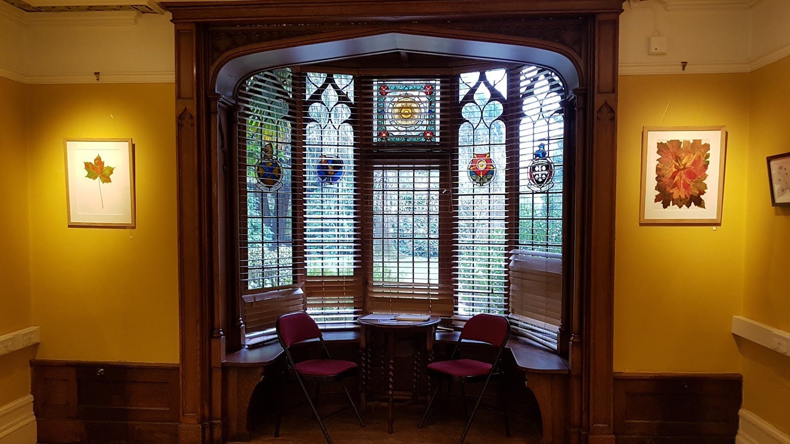 Cozy meeting space with stained glass in Didsbury Parsonage Trust for intimate gatherings.