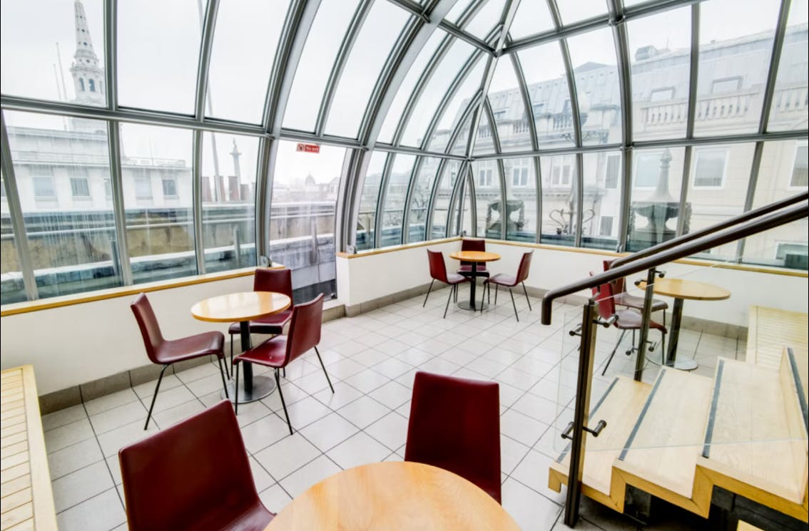 Bright modern meeting space with glass windows at London Coliseum for gatherings.