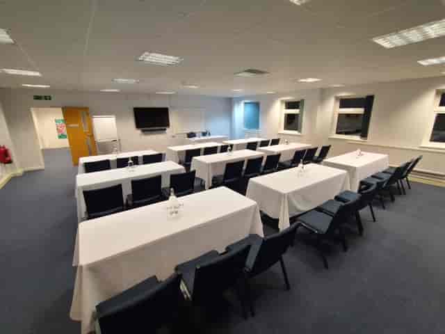 Hinksey Room at The King's Centre, Oxford: professional meeting space with tables and screen.