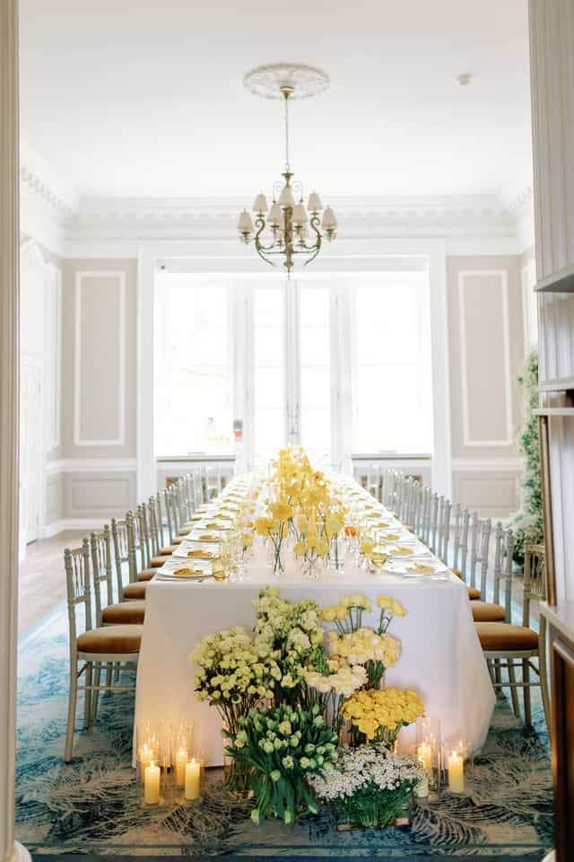 Elegant long table with yellow flowers in Brabourne Room for sophisticated events.