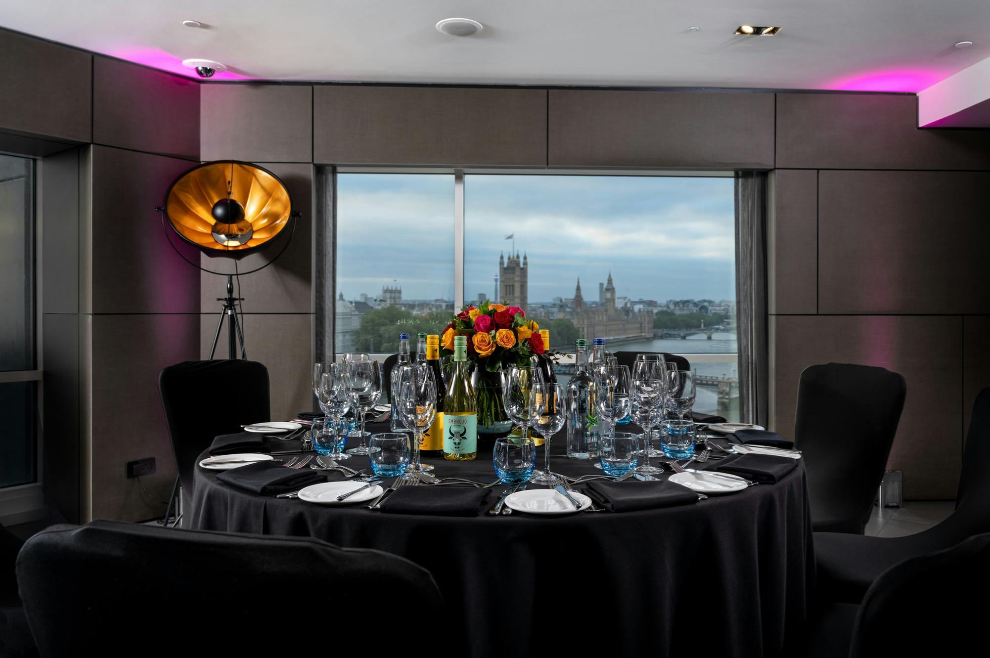 Riverview Lounge event setup with elegant table, floral centerpieces, and city skyline.