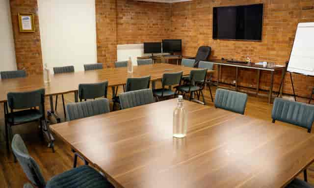 Yellow Room in Remark! Events: modern meeting space with collaborative tables, ideal for workshops.