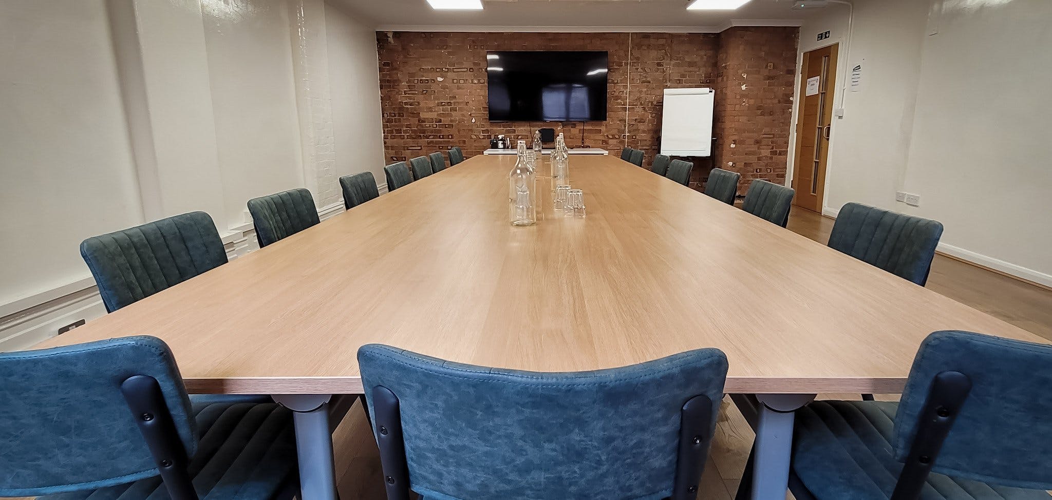 Blue Room meeting space with wooden table, ideal for collaborative events and presentations.