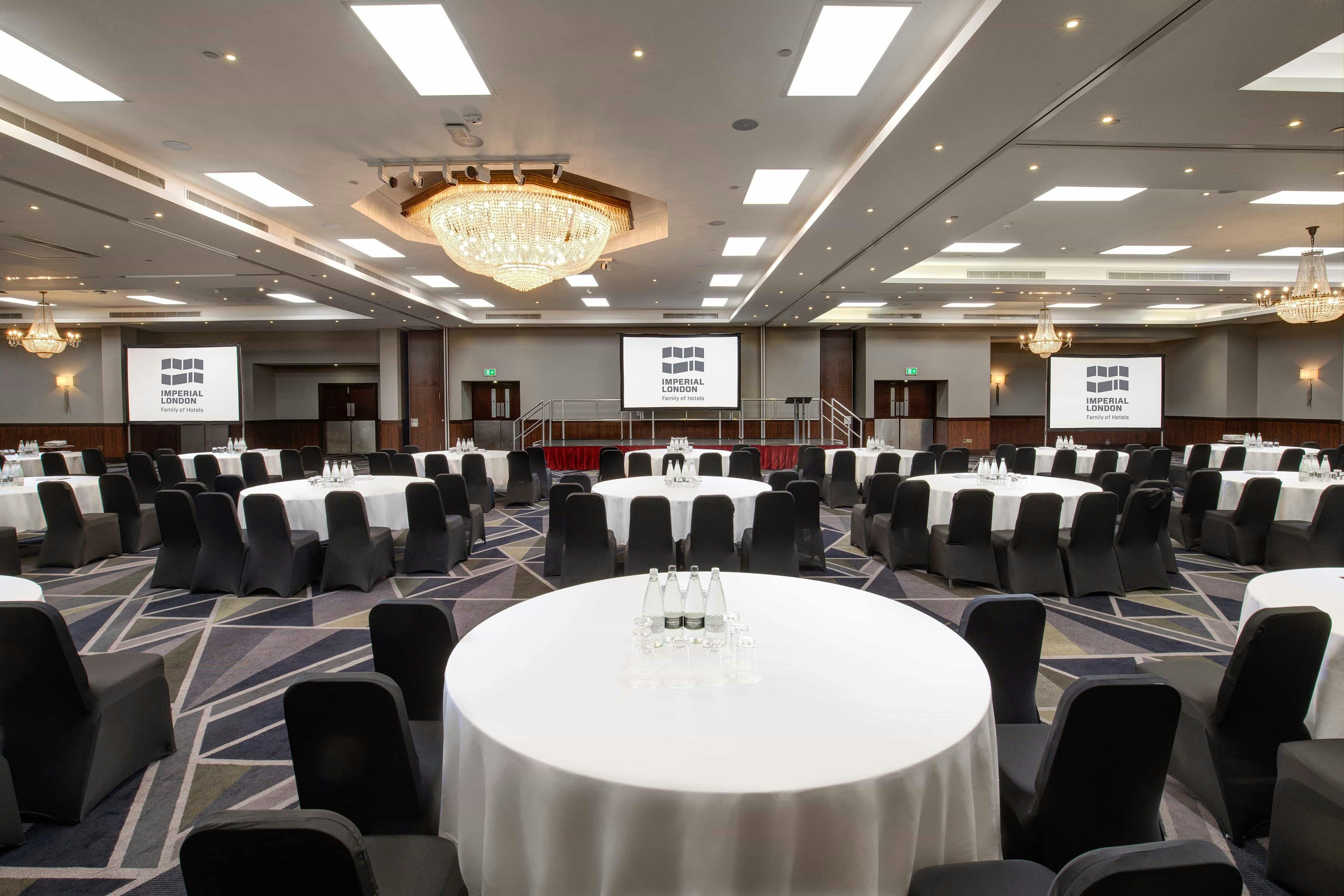 Galleon Total conference setup with round tables and elegant chandelier in Royal National Hotel.