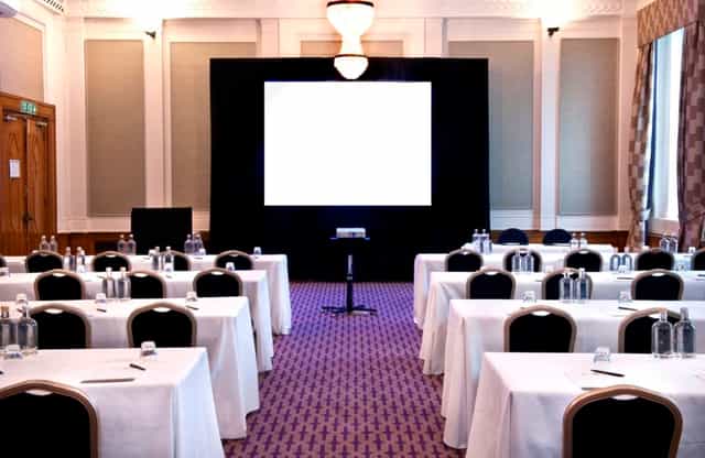Cambria Suite meeting room with tables, notepads, ideal for corporate events and workshops.