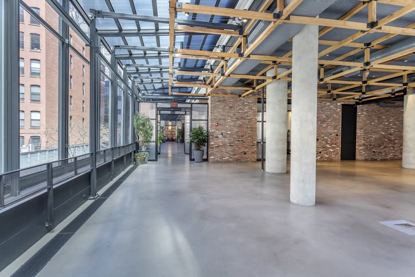 Spacious modern event venue with large windows, ideal for corporate meetings and gatherings.
