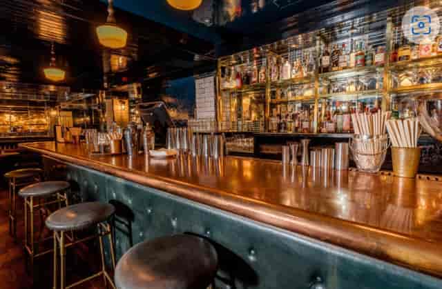 Stylish bar with polished wood counter at Hawksmoor Spitalfields for events and receptions.