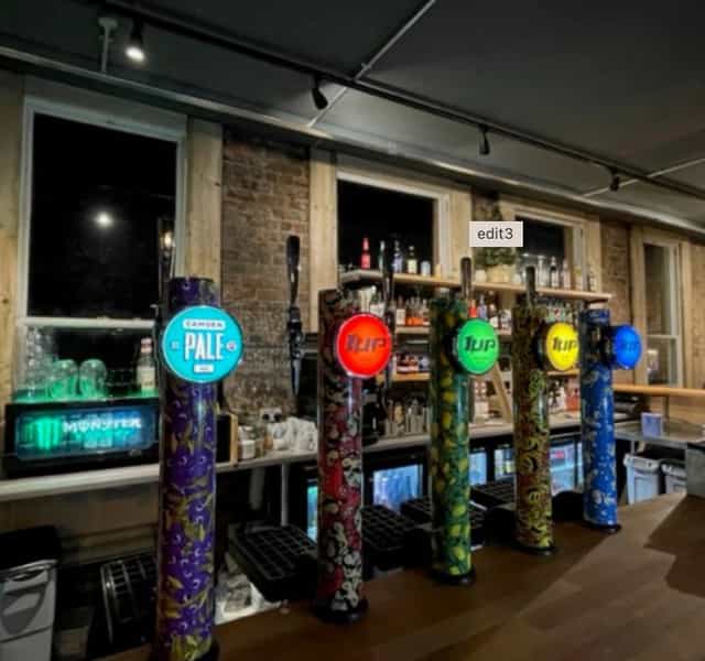 Vibrant bar with colorful beer taps at 1 Up Didsbury, ideal for events and gatherings.