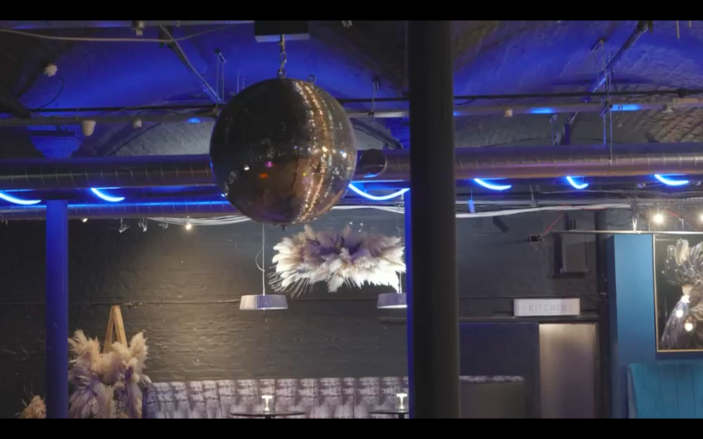 Stylish event space in The Den with a disco ball, perfect for celebrations and gatherings. - Banner