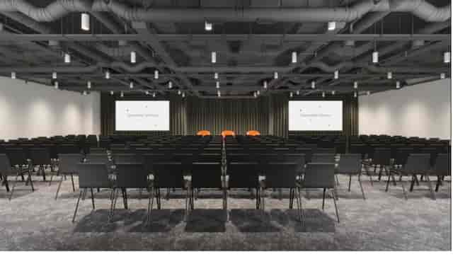 Minster Forum conference venue with black chairs and large screens for presentations.