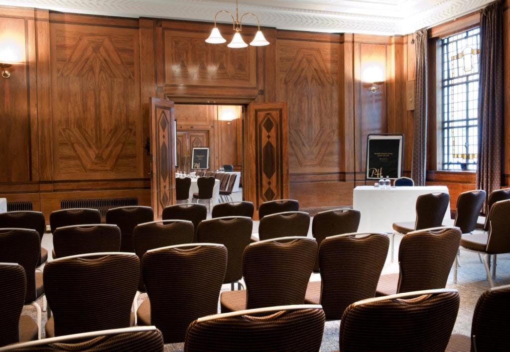 Devon Suite meeting room with elegant wood paneling for presentations and events.