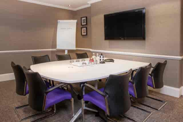 Modern meeting room with round table, ideal for strategic meetings and team workshops.