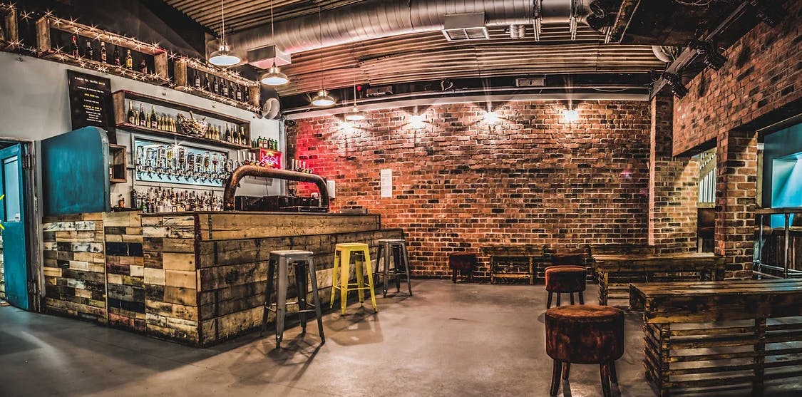 Trendy bar with exposed brick, ideal for networking events and casual gatherings.