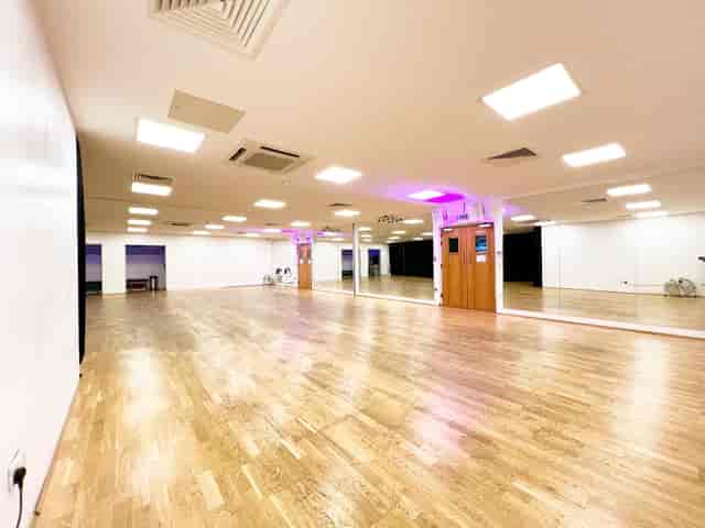 Versatile event space with polished wooden floors, ideal for workshops and fitness classes.