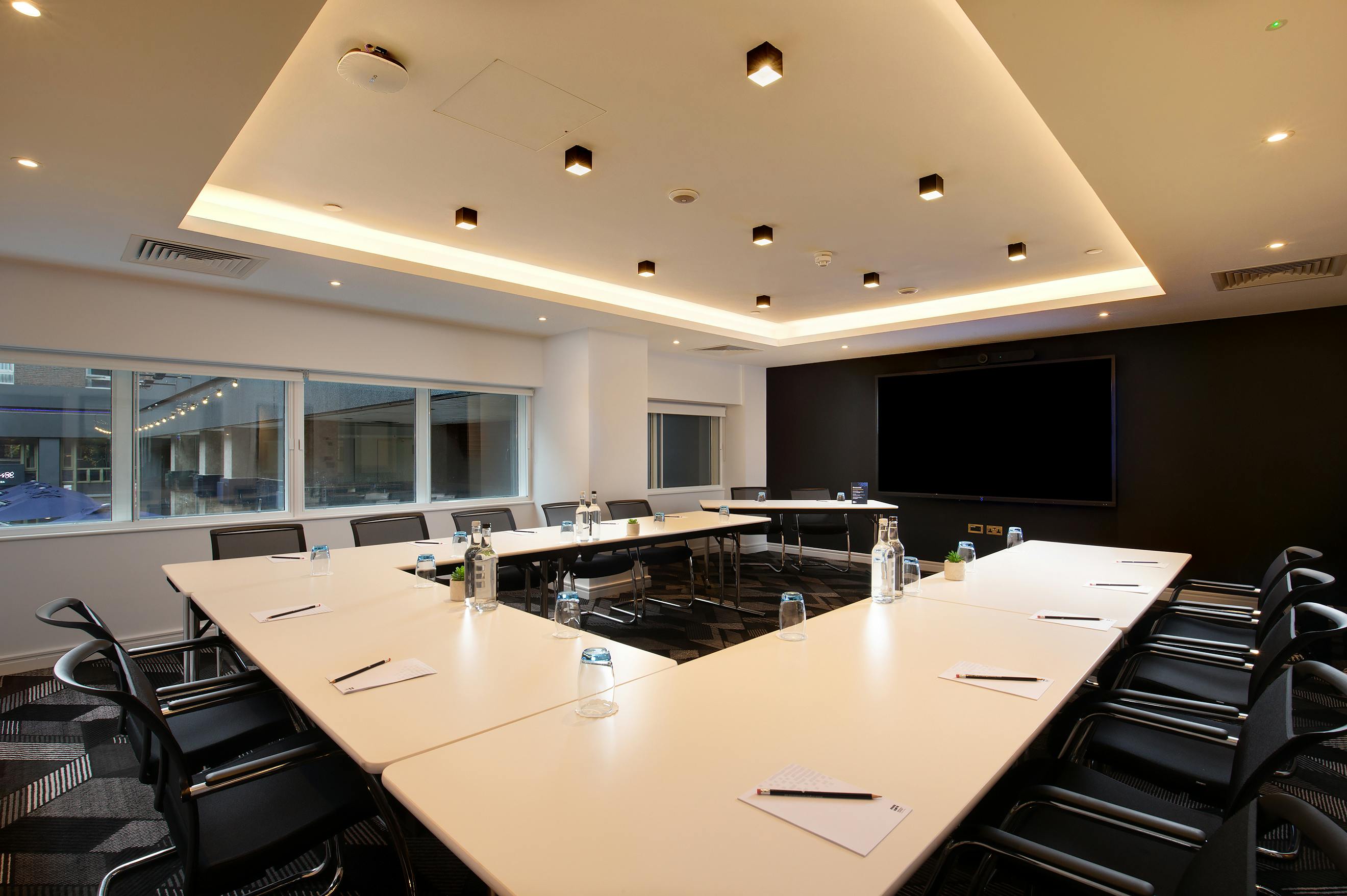 Modern meeting room at Royal National Hotel with U-shaped table for workshops.