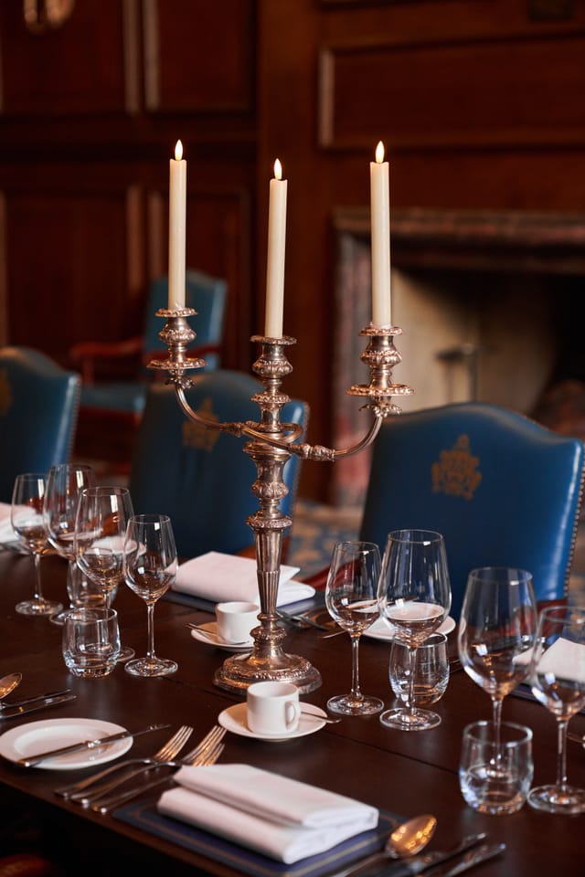 Elegant dining table in The Great Hall, featuring a silver candelabra for formal events.