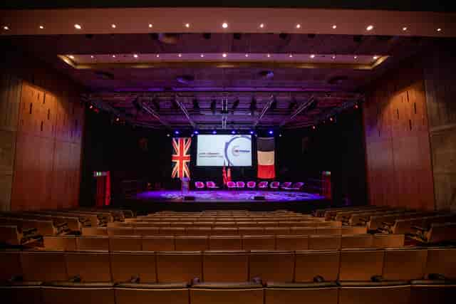 Purcell Room conference setup with stage, seating, and presentation screens.