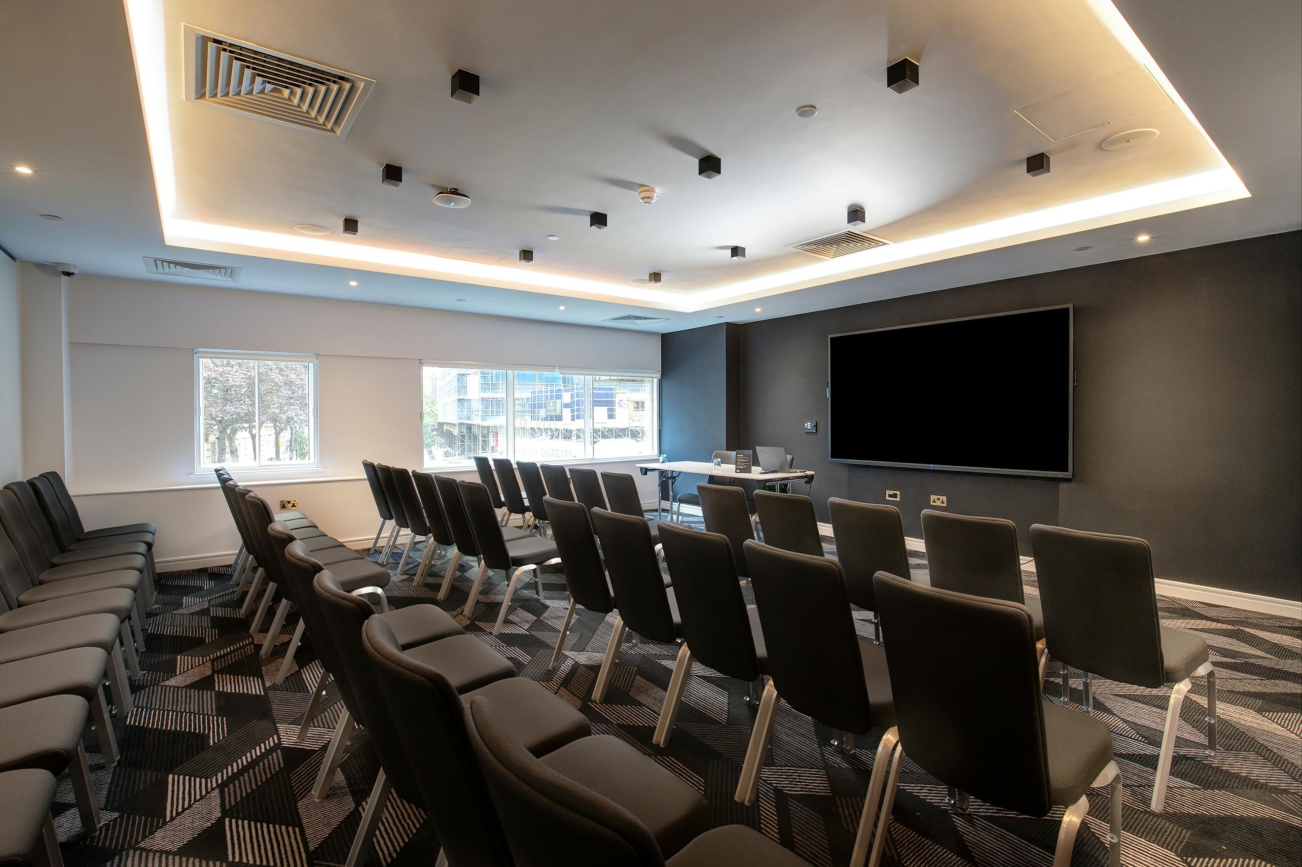 Modern meeting room at Royal National Hotel with ergonomic chairs for professional events.