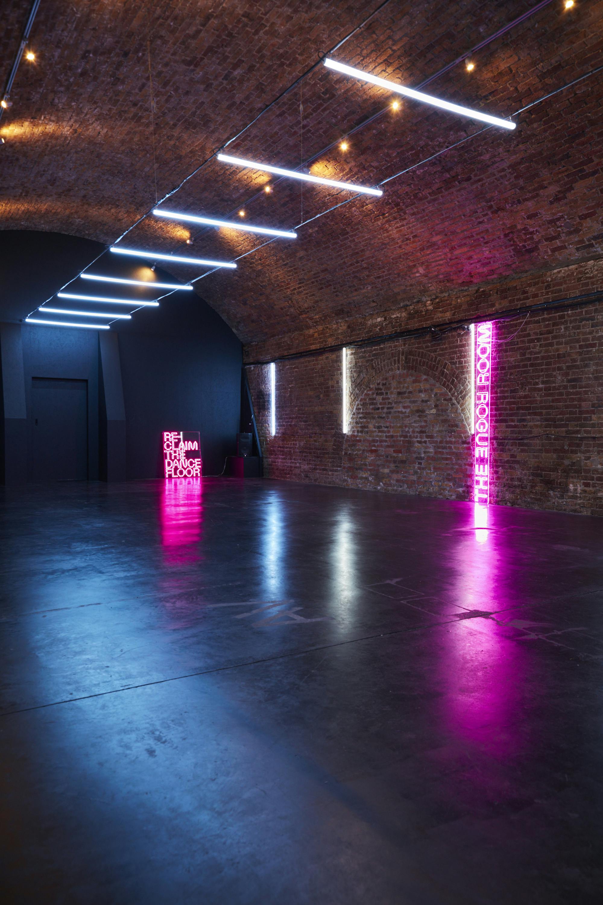 Modern event space with exposed brick and neon lighting, perfect for product launches.