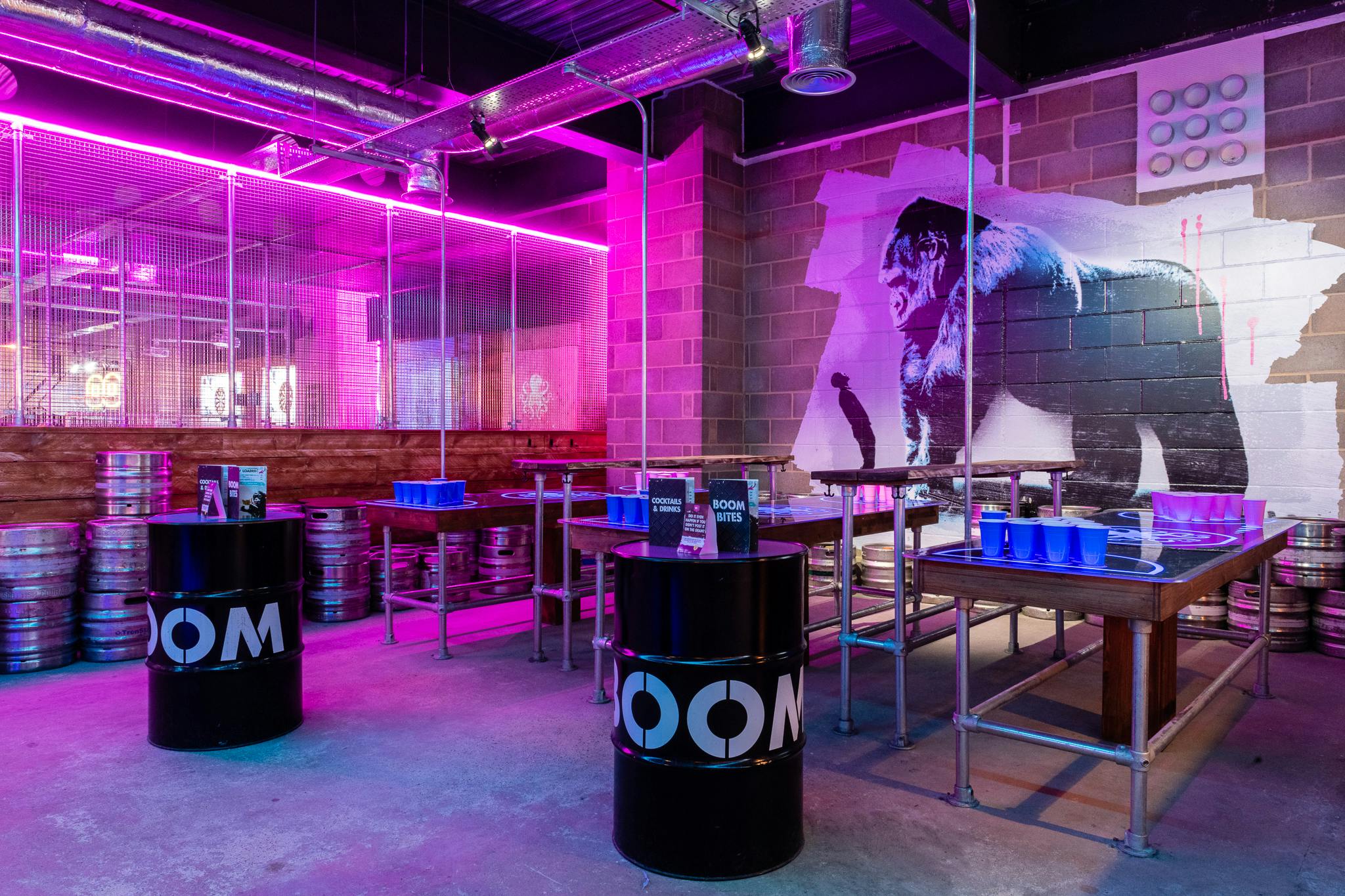 Vibrant event space with neon lights and barrel tables for parties in Oxford Street.