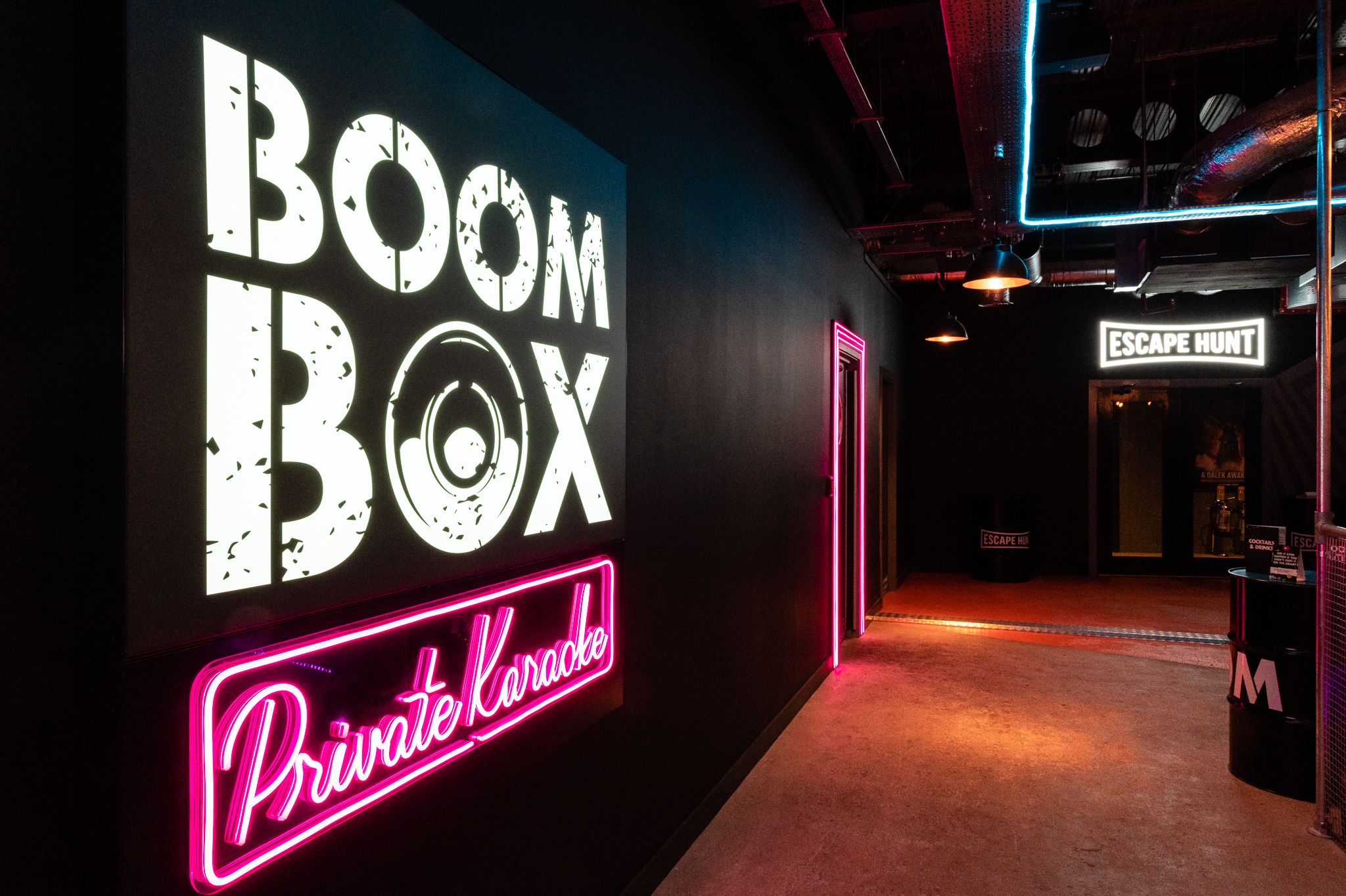 Vibrant Boom Battle Bar entrance with neon lights for team-building events and karaoke. - Banner