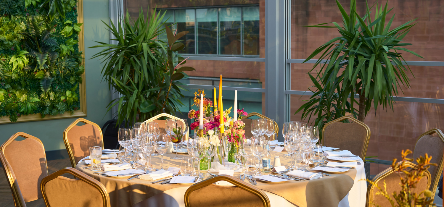Elegant dining table with fresh flowers in Manchester Hall for high-end events. - Banner