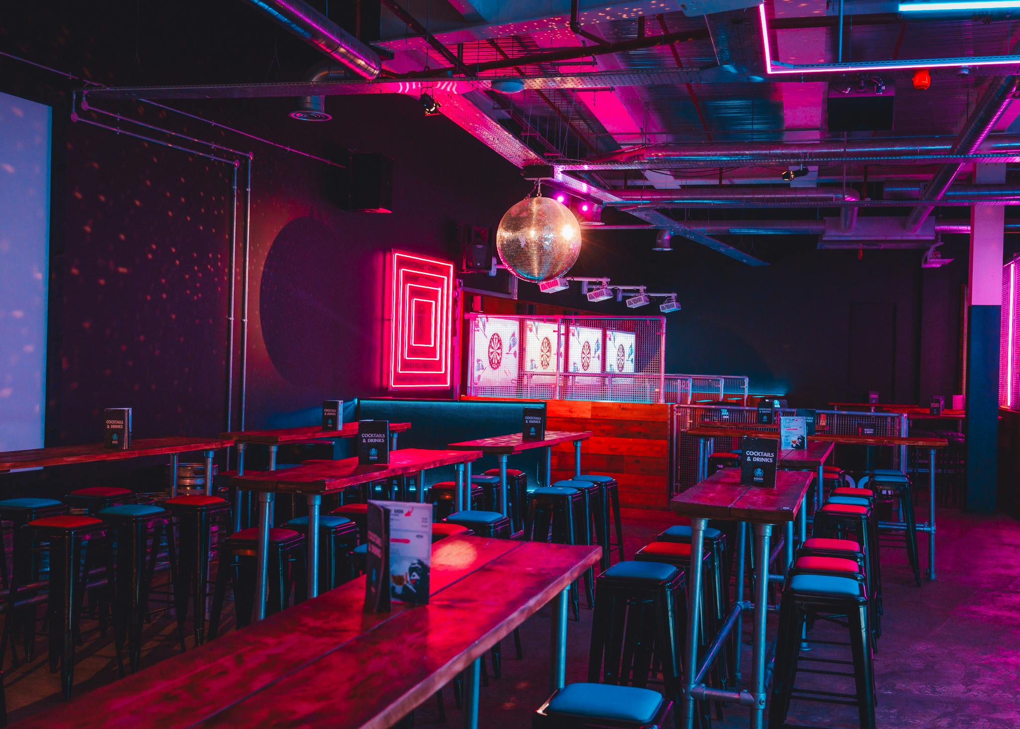 Vibrant party packages in Boom Battle Bar Leeds with neon decor and disco ball.