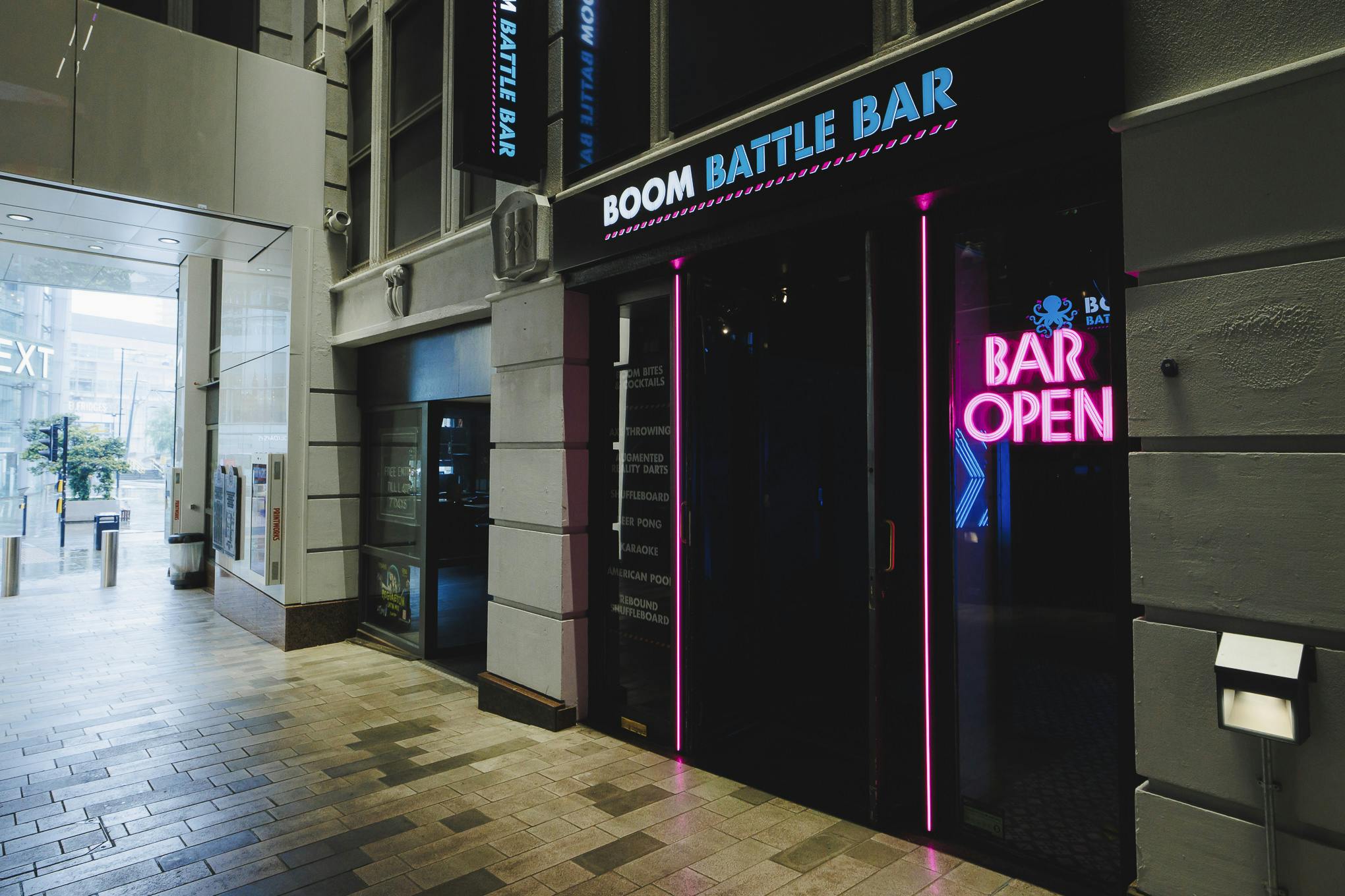 Boom Battle Bar Manchester entrance with neon sign for vibrant team-building events.