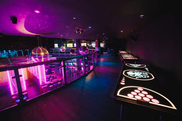 Vibrant event space with illuminated tables for networking and social celebrations in Manchester.