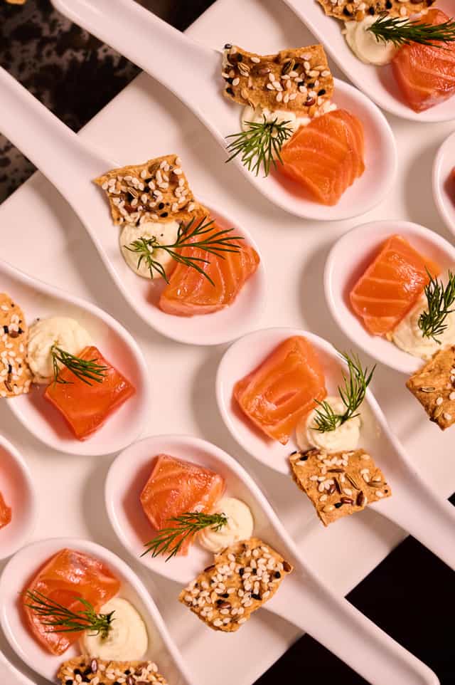Elegant salmon hors d'oeuvres on spoons at London Coliseum for upscale events.