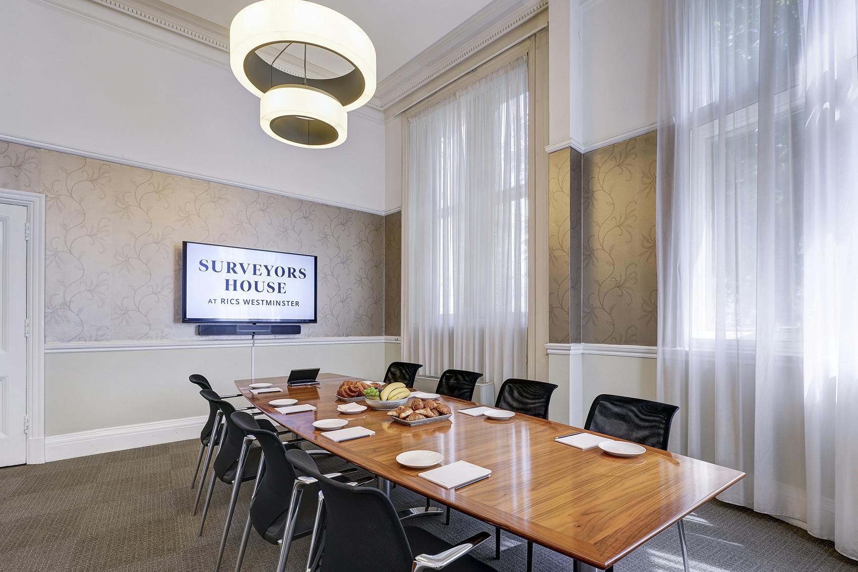 Meeting room in Dubai's Surveyors House with wooden table, ideal for corporate events.