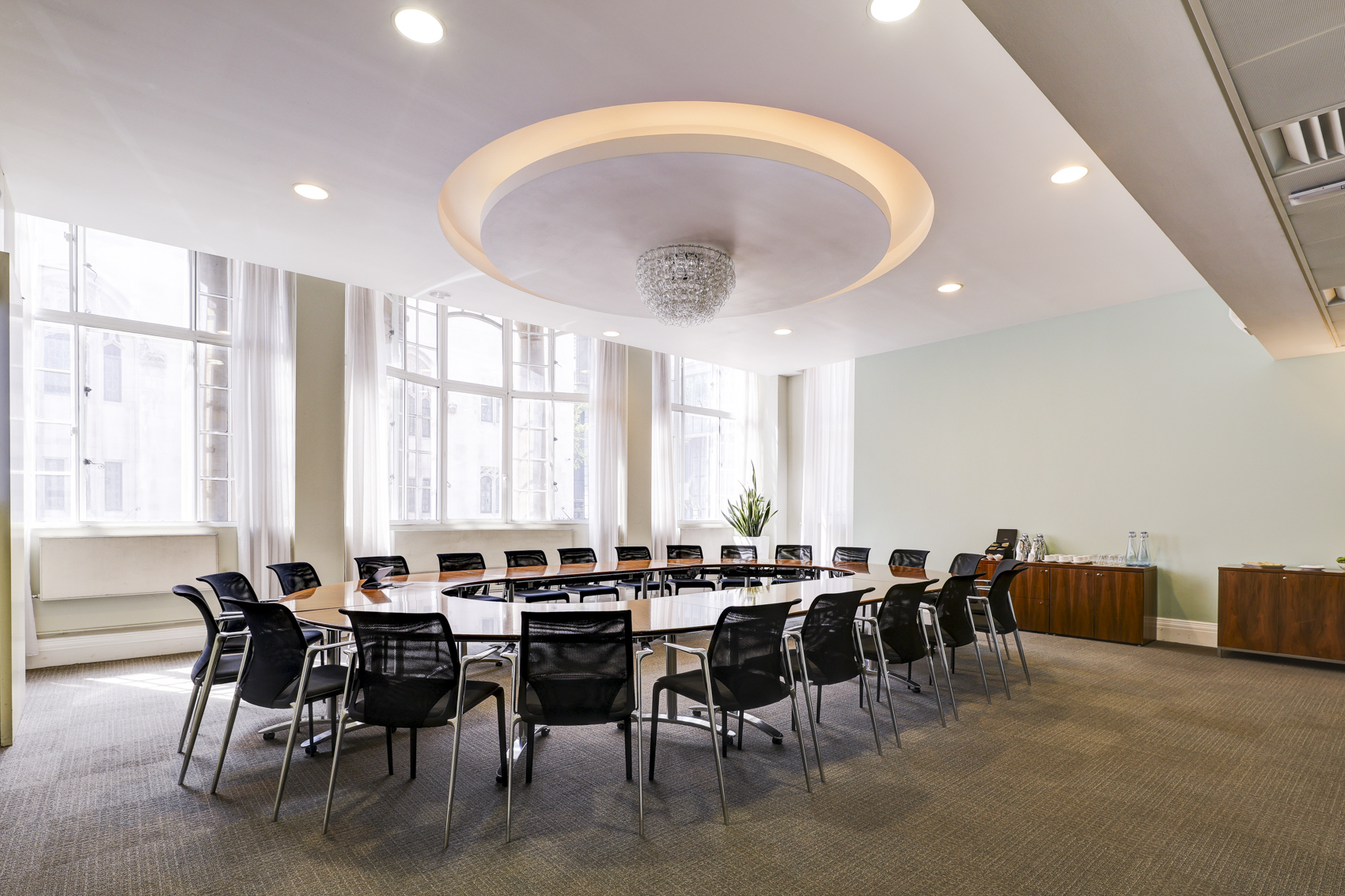 Modern conference room in Brussels with circular table, ideal for meetings and events. - Banner