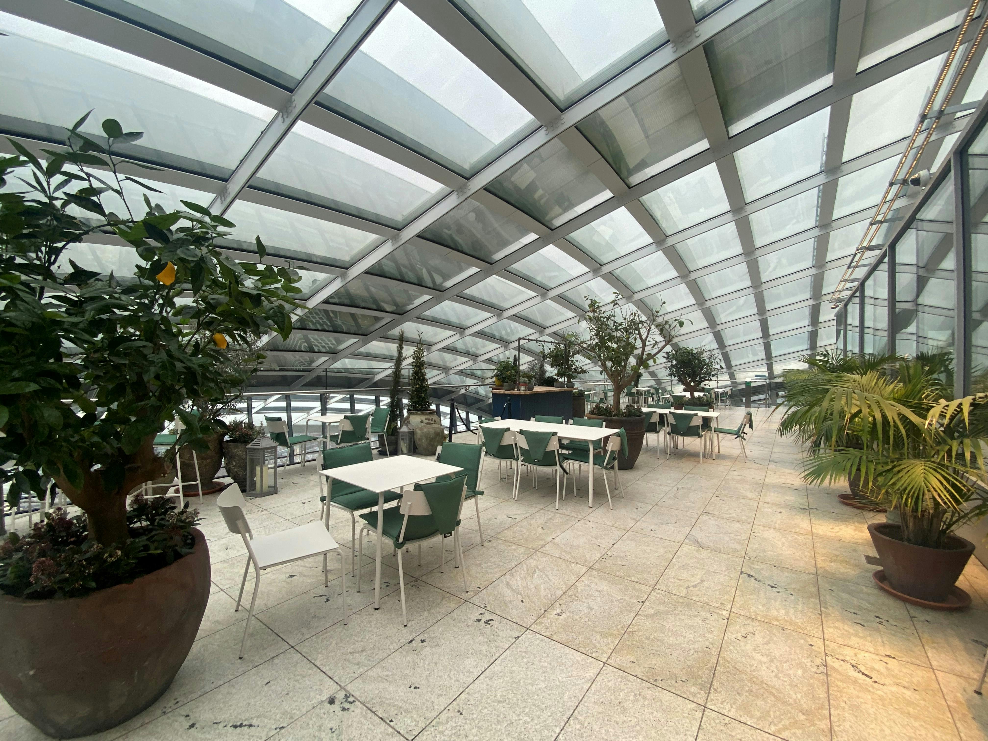 Fenchurch Terrace in Sky Garden London, modern event space with glass roof and greenery.