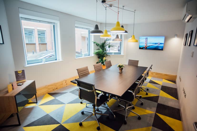 Modern meeting room with large table, ergonomic chairs for collaborative events.