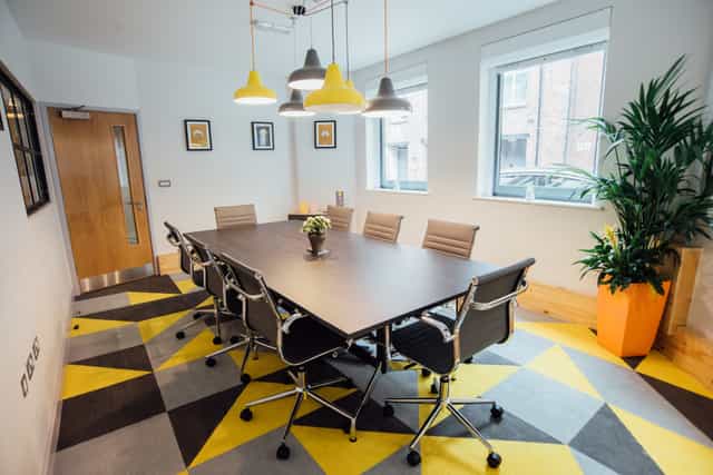 Modern meeting room with large table and ergonomic chairs for collaborative sessions.