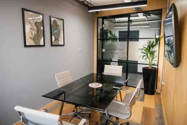 Modern Hathersage Suite huddle room with glass table for hybrid meetings and business workshops.